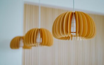 Plafonnier en bois clair illuminant un salon moderne, créant une atmosphère chaleureuse et apaisante.